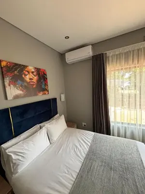 a bedroom with a white bed and a window at Glow Events & Guest House in Centurion