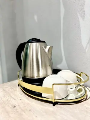 a tea kettle and two cups on a plate at Glowti Event & Guest House in Centurion