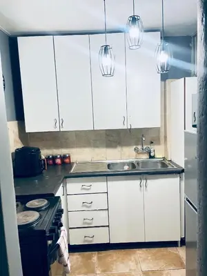 a kitchen with white cabinets and a sink at Sunnyside hidden gem in Pretoria