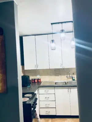 a kitchen with white cabinets and a sink at Sunnyside hidden gem in Pretoria