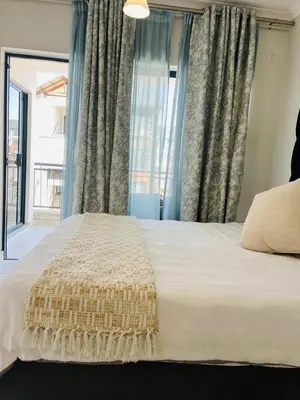 a bedroom with a large white bed with a window at Mish at The Blyde Crystal lagoons in Pretoria