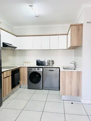 a large kitchen with a dishwasher and a sink at Mish at The Blyde Crystal lagoons in Pretoria