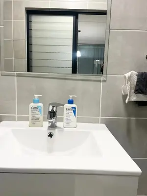 a bathroom sink with two bottles of soap on it at Mish at The Blyde Crystal lagoons in Pretoria