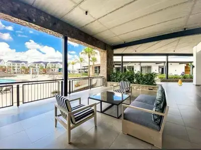 a living room with a table and chairs on a balcony at Mish at The Blyde Crystal lagoons in Pretoria