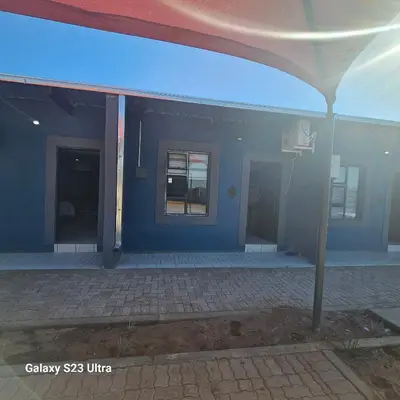 an empty building with a blue wall and a porch at Yello Guest House and Spa in Louis Trichardt