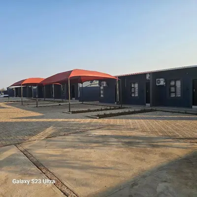 a row of buildings with a red roof at Yello Guest House and Spa in Louis Trichardt