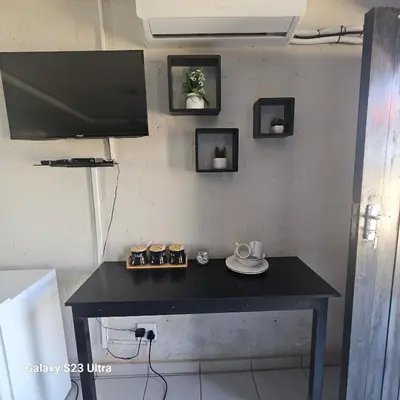a black table with a tv on a wall at Yello Guest House and Spa in Louis Trichardt