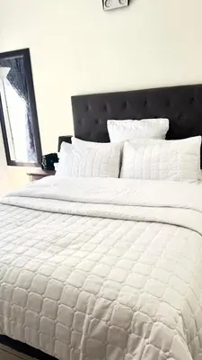 a white bed with white sheets and pillows at Prospect Guest House in Pretoria