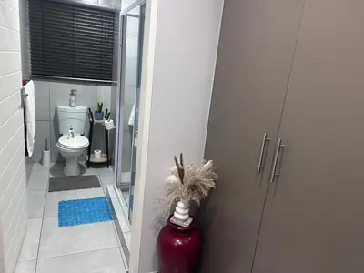 a bathroom with a toilet and a glass door at Private Space in a House in Pretoria