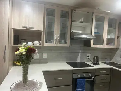 a kitchen with a vase of flowers on a counter at Private Space in a House in Pretoria