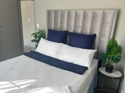 a bed with blue and white pillows on it at Private Space in a House in Pretoria