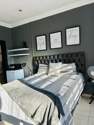 a bedroom with a large bed with three pictures on the wall at Enawe Lodge in Erasmus