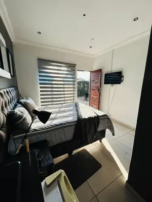 a bedroom with a bed and a couch and a window at Enawe Lodge in Erasmus