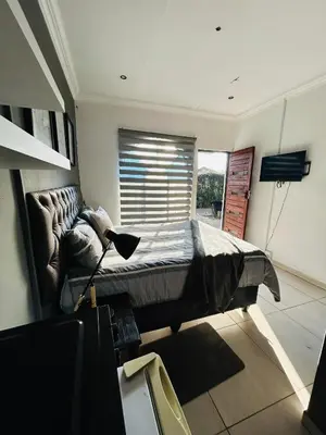 a bedroom with a large bed with a window at Enawe Lodge in Erasmus