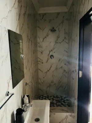 a bathroom with a sink and a shower with a mirror at Enawe Lodge in Erasmus