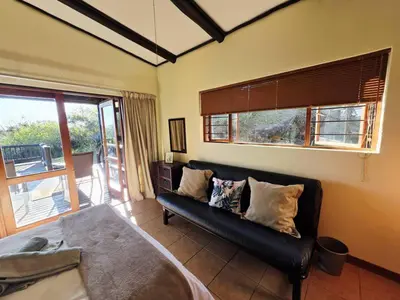 a living room with a couch and a window at Bush Willow Lodge in Hazyview