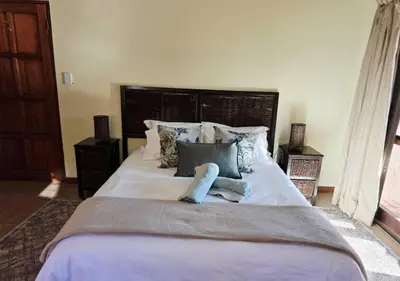 a large bed with white sheets and pillows at Bush Willow Lodge in Hazyview