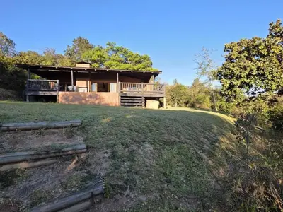 a house sitting on top of a lush green field at Bush Willow Lodge in Hazyview