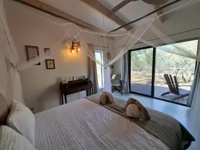 a bedroom with a bed with two teddy bears on it at TheView Marloth Lodge in Marloth Park