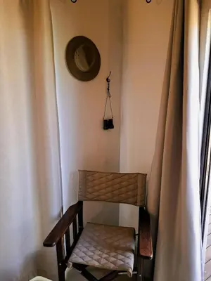 a wooden chair in a room with a window at TheView Marloth Lodge in Marloth Park