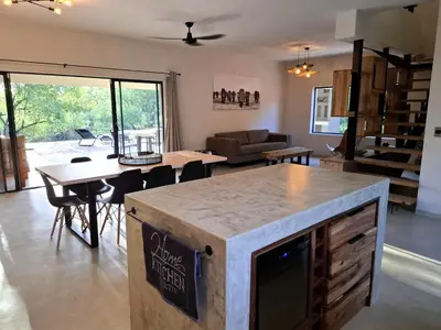 a kitchen and living room with a table and chairs at TheView Marloth Lodge in Marloth Park