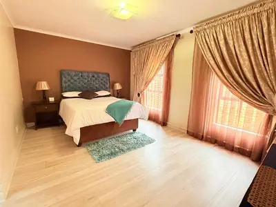 a bedroom with a bed and two windows at Secure Home on Fuchs in Polokwane