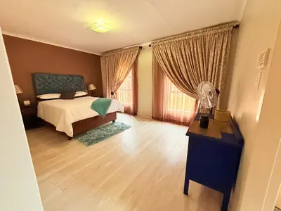 a bedroom with a bed and a large window at Secure Home on Fuchs in Polokwane