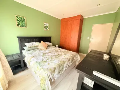 a bedroom with a bed and a table in it at Secure Home on Fuchs in Polokwane