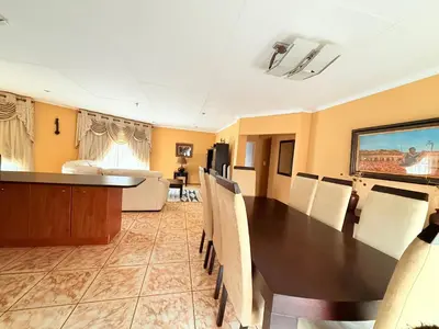 a dining room with a table and chairs and a couch at Secure Home on Fuchs in Polokwane
