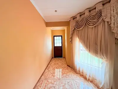 a hallway with a window and a tiled floor at Secure Home on Fuchs in Polokwane