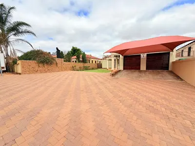 a brick driveway in front of a building with a red roof at Secure Home on Fuchs in Polokwane