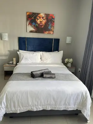 a bedroom with a white bed with two towels on it at Glowti Events & Guest House in Centurion