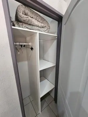 a closet with white shelves and a rope at 4 Trees Accommodation in Polokwane