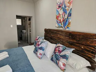 a bedroom with a bed with two pillows on it at 4 Trees Accommodation in Polokwane