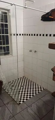 a shower with a black and white checkered floor at Inkonka Game farm