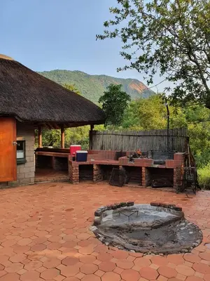 a patio with two benches and a fire pit at Inkonka Game farm