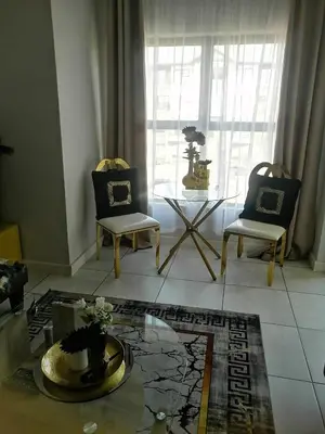 a living room with two chairs and a table at Queens at The Blyde Lagoon in Pretoria