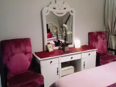 a room with two chairs and a vanity with a mirror at Queens at The Blyde Lagoon in Pretoria