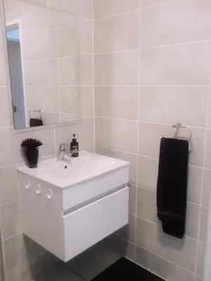 a white bathroom with a sink and a mirror at Queens at The Blyde Lagoon in Pretoria