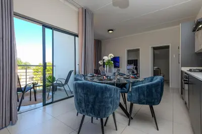 a kitchen and dining room with a table and chairs at GatesofGail Luxury Apartments in Midrand