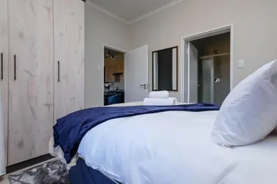 a bedroom with a large white bed and a window at GatesofGail Luxury Apartments in Midrand
