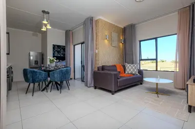 a living room with a couch and a table at GatesofGail Luxury Apartments in Midrand