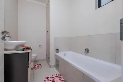 a bathroom with a tub and a sink and a toilet at GatesofGail Luxury Apartments in Midrand