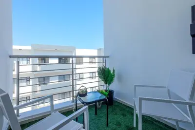 a balcony with white chairs and a potted plant at GatesofGail Luxury Apartments in Midrand