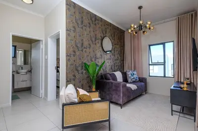 a living room with a purple couch and a table at GatesofGail Luxury Apartments in Midrand