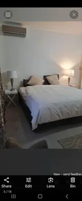a woman laying on a bed in a bedroom at Erasmia on main in Centurion