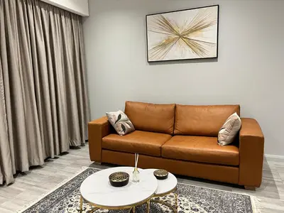 a living room with a brown couch and a table at Continental Menlyn Maine Residence in Pretoria