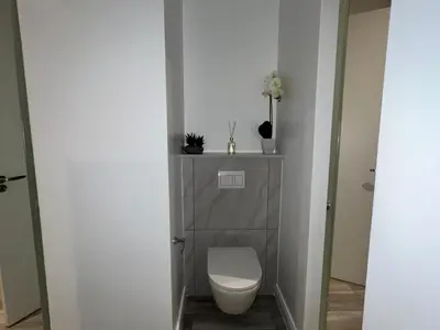 a bathroom with a white toilet in a room at Continental Menlyn Maine Residence in Pretoria