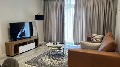 a living room with a couch and a flat screen tv at Continental Menlyn Maine Residence in Pretoria
