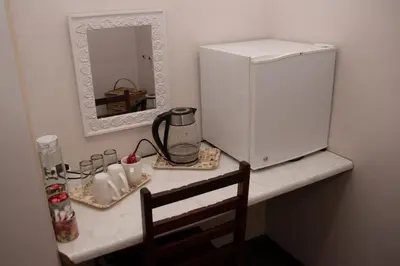 a counter top with a refrigerator and a mirror at Cairos Guest House in Witbank